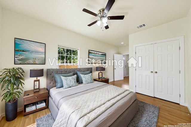 bedroom featuring a closet, wood finished floors, baseboards, visible vents, and ceiling fan