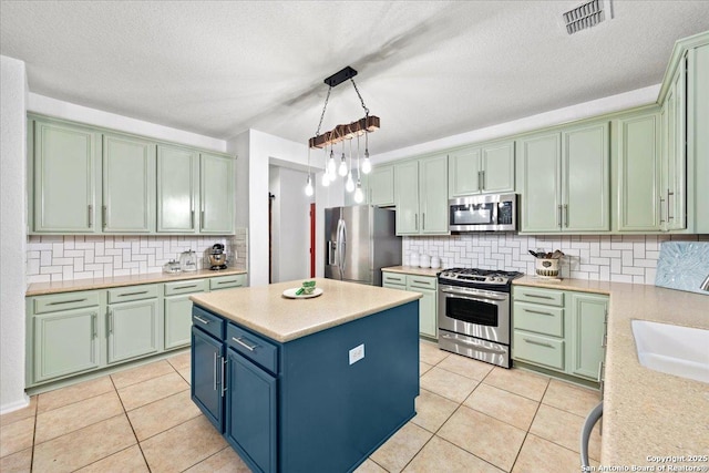 kitchen with light countertops, stainless steel appliances, a sink, light tile patterned flooring, and visible vents