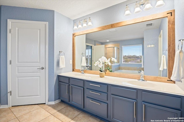 full bath with visible vents, a sink, tile patterned floors, and a shower stall