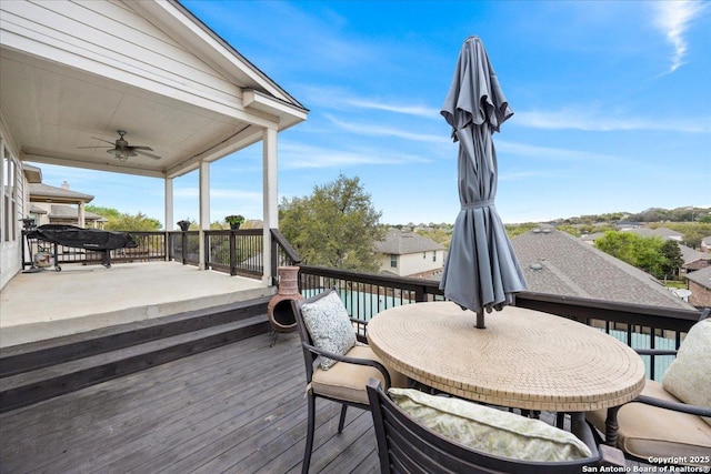 wooden terrace with outdoor dining space and ceiling fan