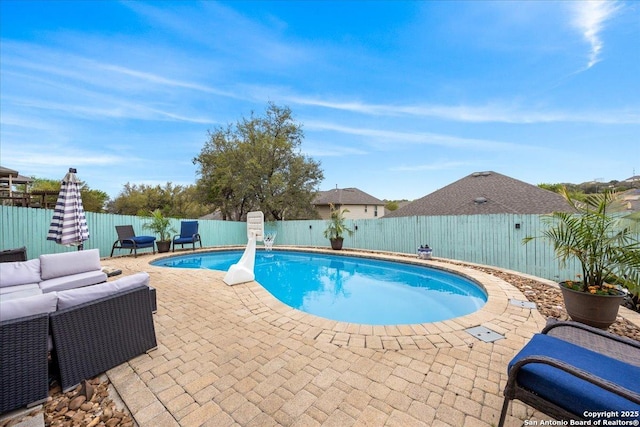 view of swimming pool with outdoor lounge area, a fenced in pool, a fenced backyard, and a patio area