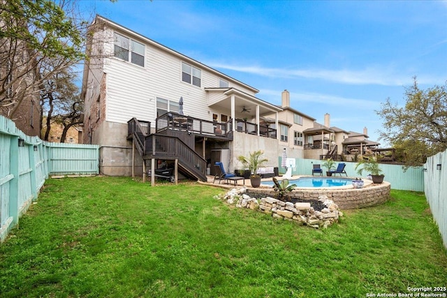 back of house with stairs, a fenced in pool, a fenced backyard, a deck, and a yard