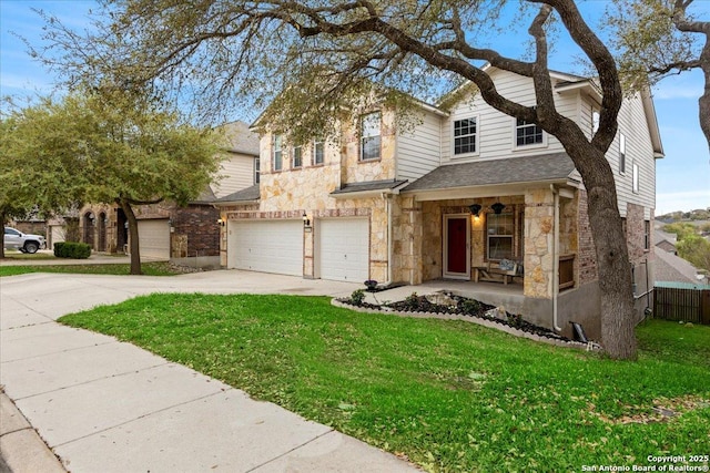 traditional home featuring stone siding, fence, an attached garage, concrete driveway, and a front yard