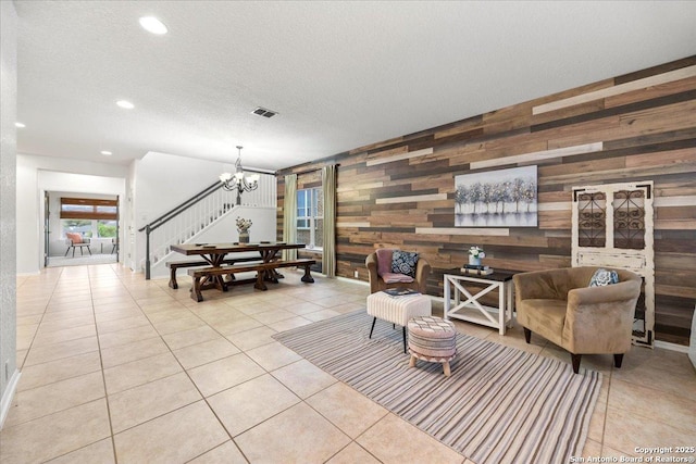 living area featuring stairs, visible vents, a chandelier, and light tile patterned floors