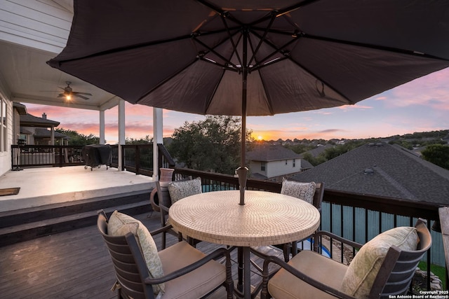 deck at dusk featuring outdoor dining area