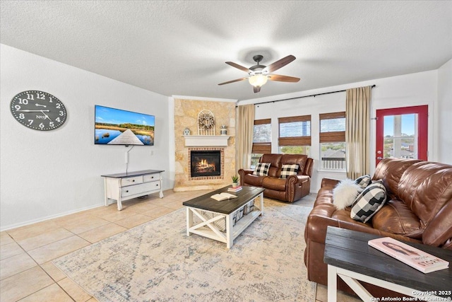 living area featuring a textured ceiling, ceiling fan, tile patterned flooring, and plenty of natural light