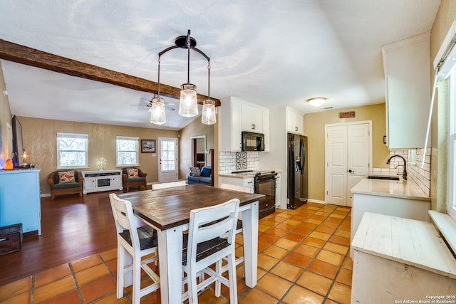 dining area featuring a ceiling fan, light tile patterned floors, beam ceiling, and a wealth of natural light