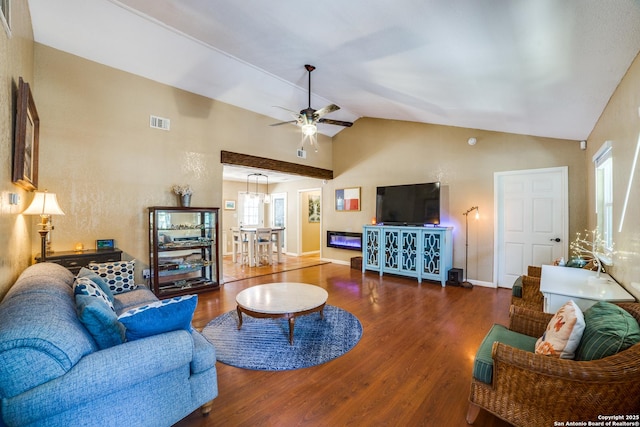 living area featuring ceiling fan, visible vents, vaulted ceiling, and wood finished floors