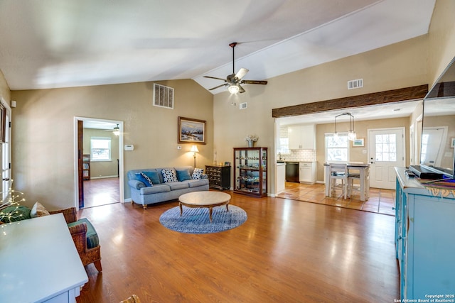 living room featuring visible vents, wood finished floors, ceiling fan, and vaulted ceiling