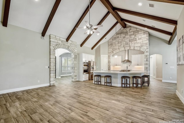 1609 Havenwood, New Braunfels, TX 78132 - unfurnished living room with high vaulted ceiling, light wood-style flooring, visible vents, a ceiling fan, and arched walkways