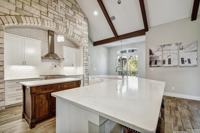 1609 Havenwood, New Braunfels, TX 78132 - kitchen featuring decorative backsplash, wall chimney exhaust hood, beamed ceiling, and a large island with sink