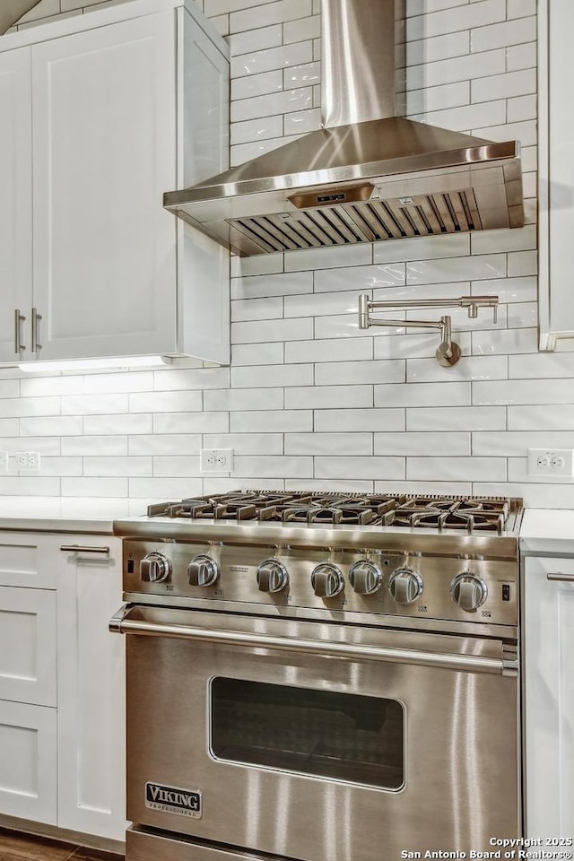 1609 Havenwood, New Braunfels, TX 78132 - kitchen featuring backsplash, white cabinetry, luxury stove, and wall chimney exhaust hood