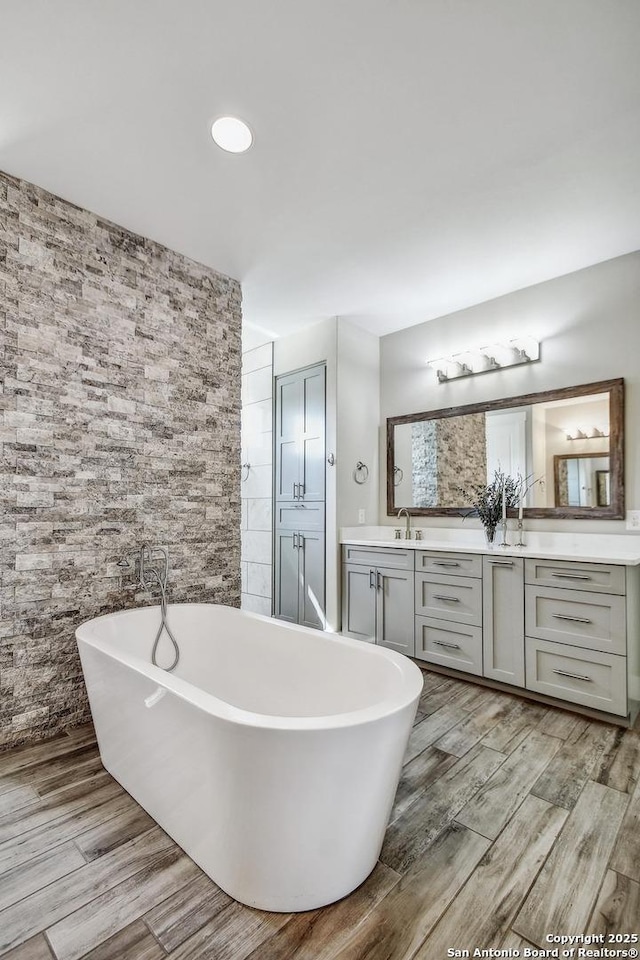 1609 Havenwood, New Braunfels, TX 78132 - bathroom with a soaking tub, vanity, and wood finished floors
