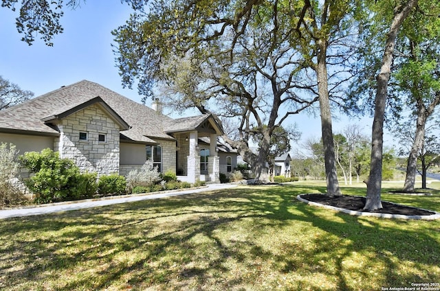 1609 Havenwood, New Braunfels, TX 78132 - view of front of home featuring stone siding, a front yard, a shingled roof, and a chimney