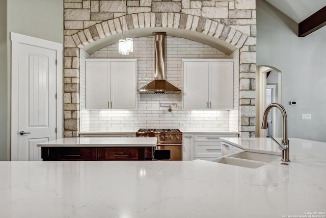 1609 Havenwood, New Braunfels, TX 78132 - kitchen with stainless steel stove, backsplash, a sink, wall chimney range hood, and white cabinets
