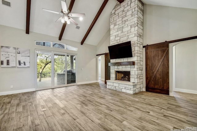 1609 Havenwood, New Braunfels, TX 78132 - unfurnished living room featuring visible vents, a barn door, wood finished floors, and ceiling fan