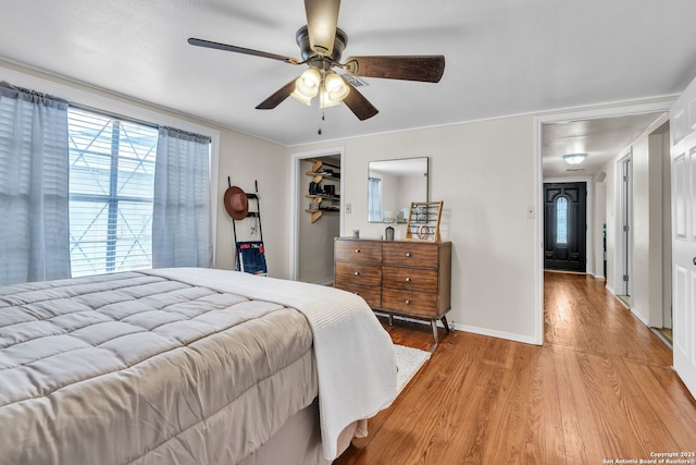 bedroom with baseboards, ceiling fan, a closet, and light wood-style flooring