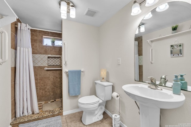 full bath featuring toilet, a tile shower, tile patterned flooring, and visible vents