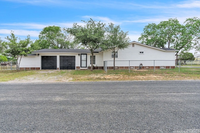view of front of home with fence, driveway, and an attached garage