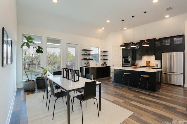 dining space with high vaulted ceiling, visible vents, baseboards, wood finished floors, and recessed lighting