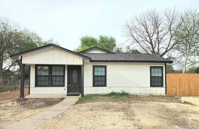 view of front of home with a shingled roof, fence, and board and batten siding