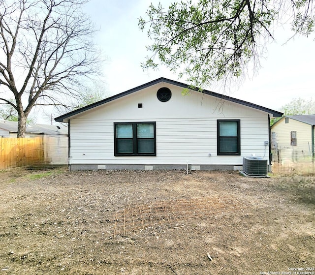 rear view of property featuring crawl space, fence, and central AC