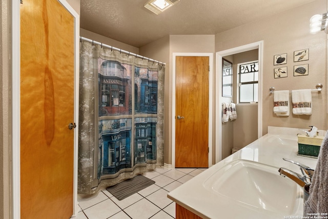 bathroom with double vanity, tile patterned flooring, and a sink