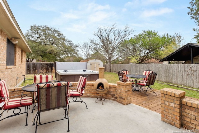 view of patio / terrace featuring a fenced backyard, an outbuilding, outdoor dining area, and a shed