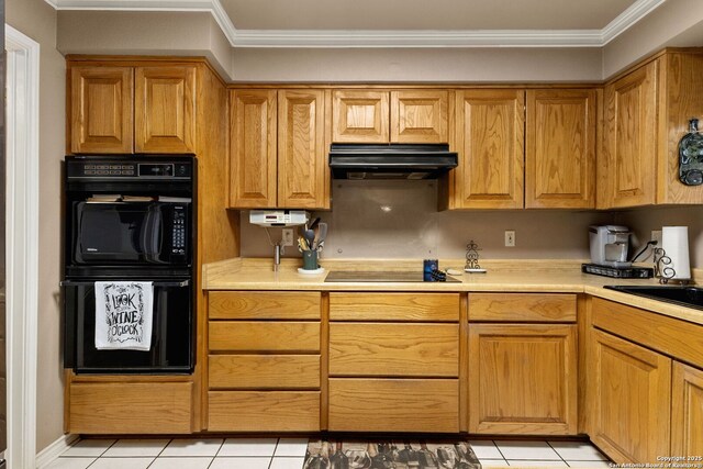 kitchen with under cabinet range hood, light countertops, black appliances, and crown molding
