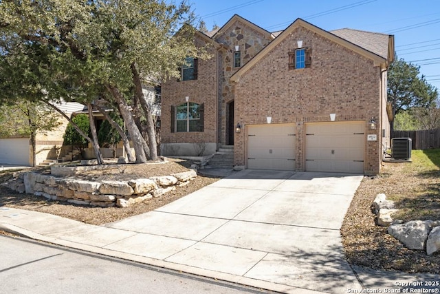 view of front of house with central AC, fence, brick siding, and concrete driveway