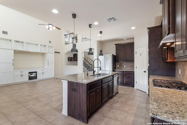 kitchen with open floor plan, stainless steel appliances, a sink, visible vents, and ventilation hood