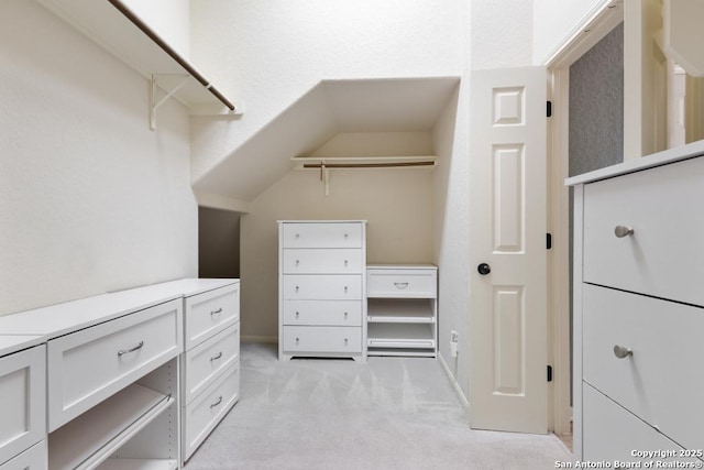 walk in closet featuring light colored carpet