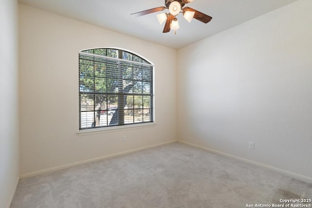 carpeted empty room featuring baseboards and ceiling fan