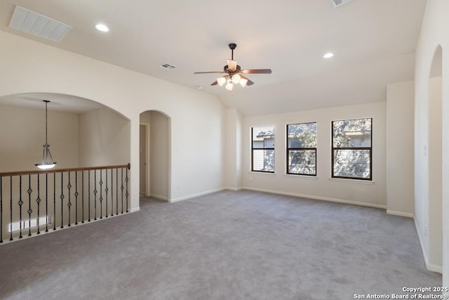 carpeted empty room featuring lofted ceiling, visible vents, recessed lighting, and a ceiling fan