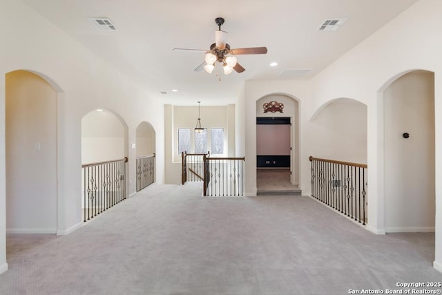 carpeted spare room with a ceiling fan, recessed lighting, baseboards, and visible vents