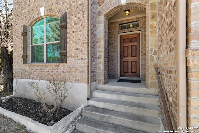 doorway to property featuring brick siding