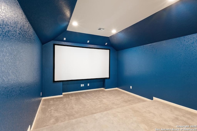 home theater room with baseboards, carpet flooring, visible vents, and vaulted ceiling