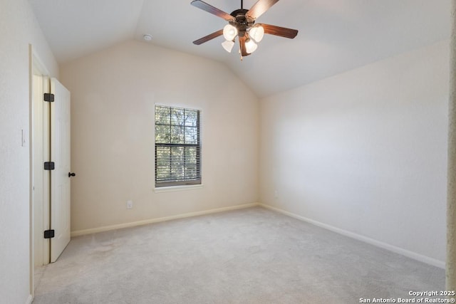 empty room featuring a ceiling fan, baseboards, lofted ceiling, and light colored carpet