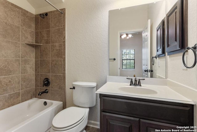 full bathroom featuring shower / bathing tub combination, toilet, vanity, and a textured wall