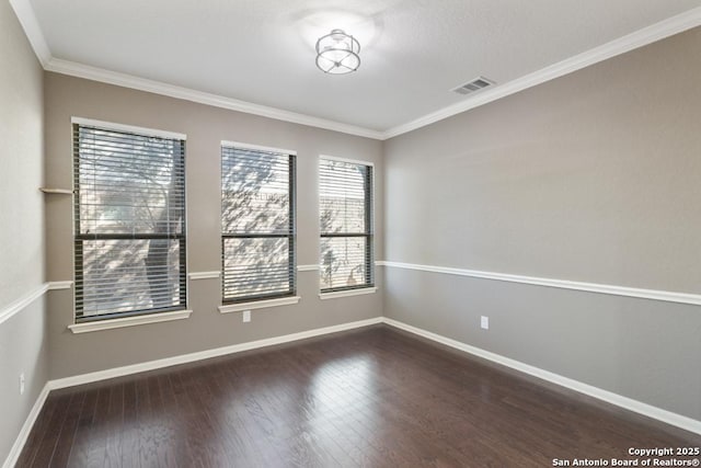 unfurnished room featuring visible vents, crown molding, baseboards, and dark wood finished floors