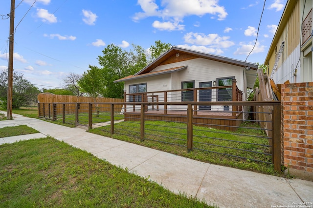 view of front of property with a gate, fence, and a front lawn