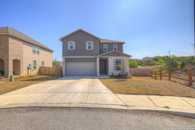 view of front of property with an attached garage, fence, and concrete driveway