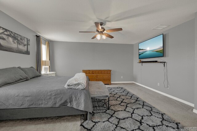 carpeted bedroom with baseboards, visible vents, and a ceiling fan