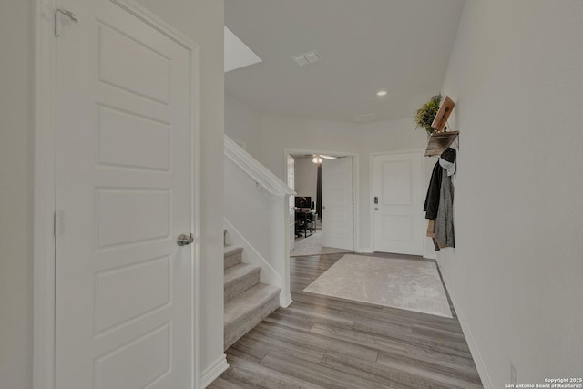 foyer entrance featuring stairs, recessed lighting, wood finished floors, and baseboards