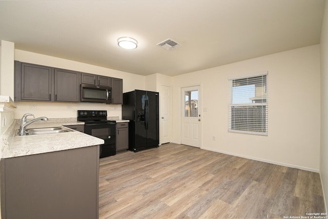 180 Elderberry, New Braunfels, TX 78130 - kitchen with light countertops, light wood-type flooring, a sink, visible vents, and black appliances