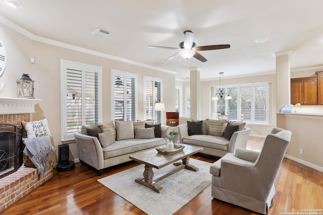 living room with decorative columns, hardwood / wood-style flooring, and a ceiling fan