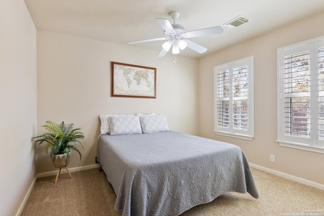 carpeted bedroom with baseboards, ceiling fan, and visible vents