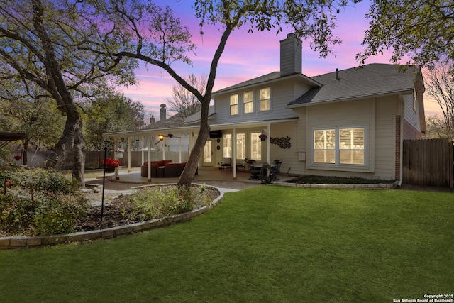 back of house featuring a yard, fence, a chimney, and a patio