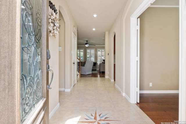 entryway featuring light tile patterned flooring, a ceiling fan, baseboards, arched walkways, and recessed lighting