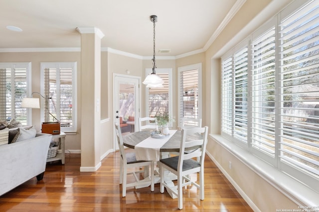 dining area with wood-type flooring, plenty of natural light, crown molding, and baseboards